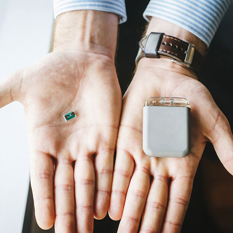 A person's hands holding a small medical device