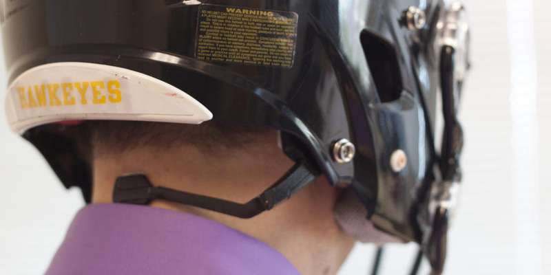 A person wearing an Iowa Hawkeyes football helmet