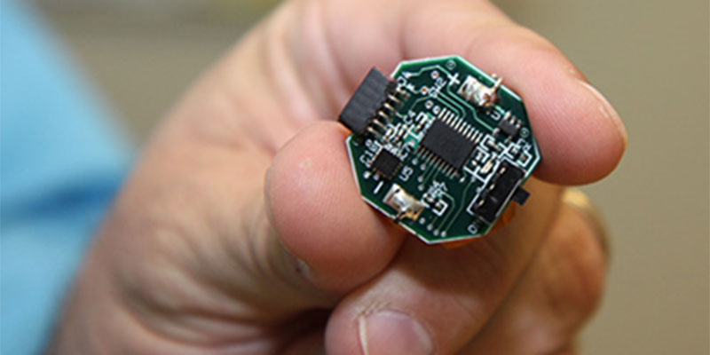 A hand holding a microchip device